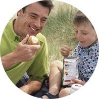 Father and son eating at the contryside