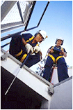 Two men with helmets looking at oil engine