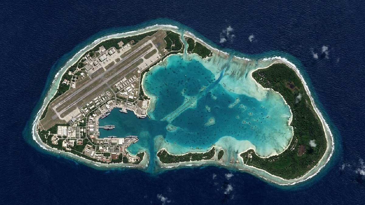Aerial view of Diego Garcia military base showing runways and naval ships.